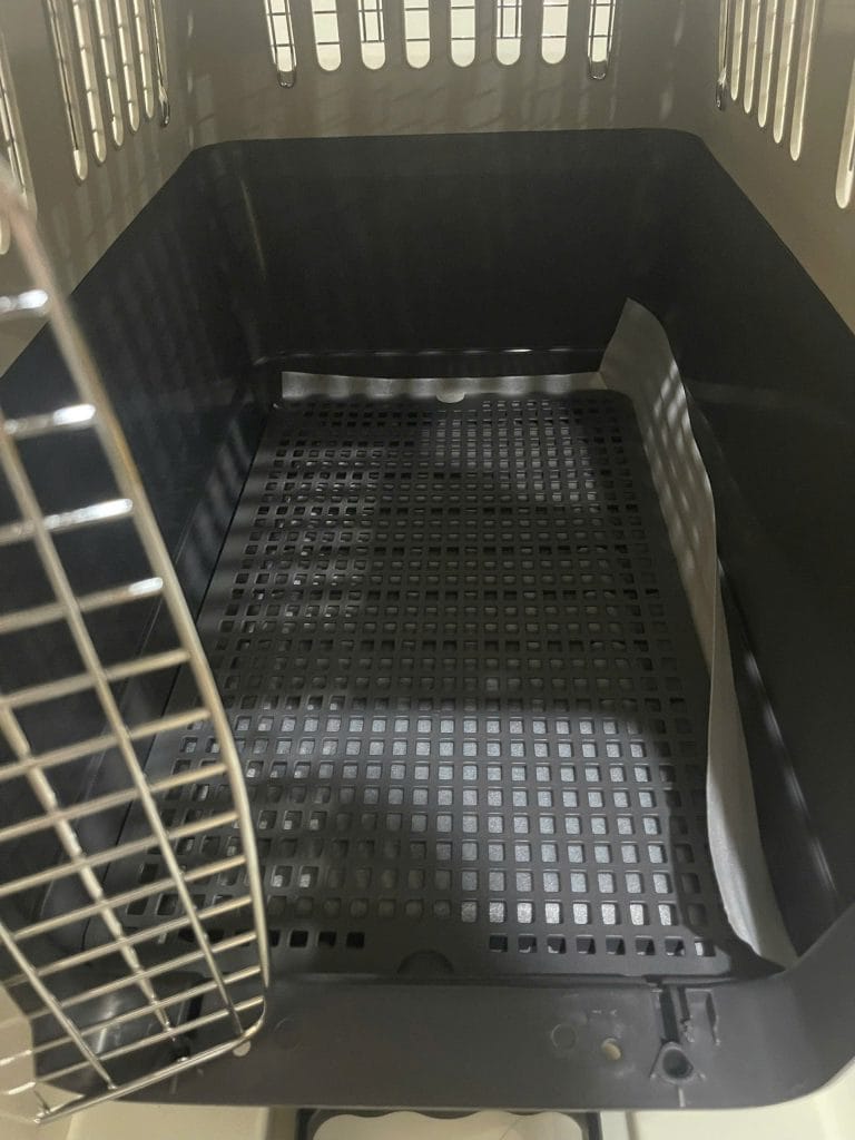 Absorbent bedding pad lining the floor of an IATA pet crate